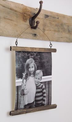 an old wooden frame hanging on the wall next to a wood hanger with a picture of two children