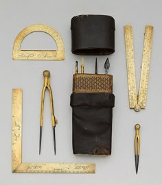 an assortment of tools are laid out on a gray surface, including scissors and tape measure