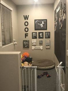 a dog gate in the corner of a room with pictures on the wall