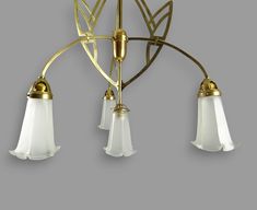 three light chandelier with white glass shades and gold trimmings on the arms