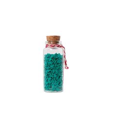 a glass jar filled with lots of green rice next to a red and white string