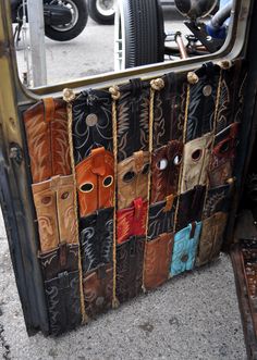 an old car door is decorated with leathers and metal bars, which are lined up in rows