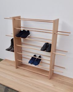 there are several pairs of shoes in the shoe rack that is made out of wood