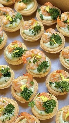 small appetizers with shrimp and broccoli on them are displayed in a box