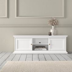 a white entertainment center in an empty room