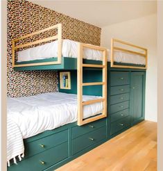 two bunk beds in a room with green drawers