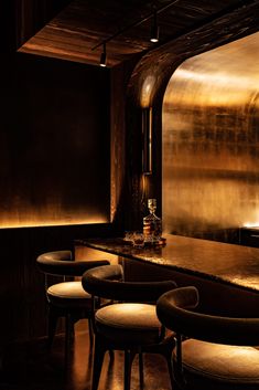 a dimly lit bar with several stools