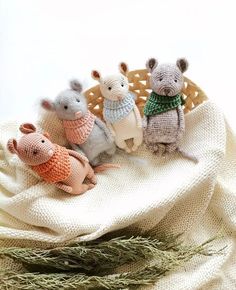 three knit mice sitting on top of a white blanket