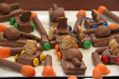 there are many chocolate treats that look like train cars and bears on the tracks with candy candies all over them