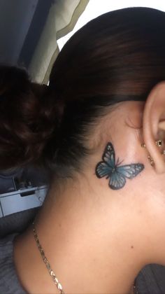 a woman with a butterfly tattoo on her ear