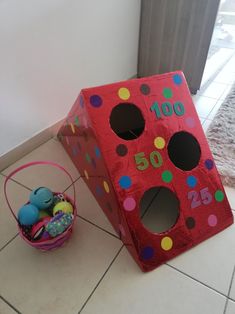 a red cardboard box with polka dots on it next to a basket filled with eggs