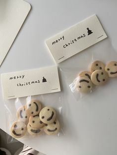 some cookies are wrapped in plastic and have faces drawn on them with words merry christmas