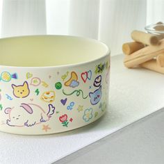 a white bowl sitting on top of a counter next to wooden utensils