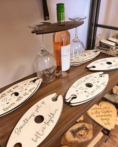 wine glasses and personalized wooden signs on a table with bottles of wine in the background