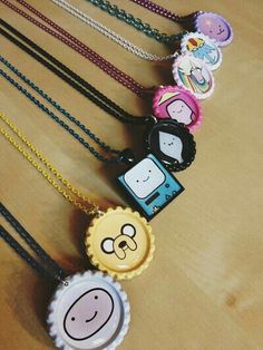 several necklaces with cartoon characters on them sitting next to each other in front of a wooden table