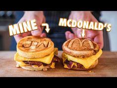 two breakfast sandwiches with the words mcdonald's written on them, and someone holding one