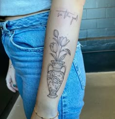 a woman with a flower vase tattoo on her arm