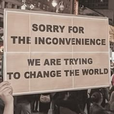 a group of people holding up signs in the middle of a street with words written on them