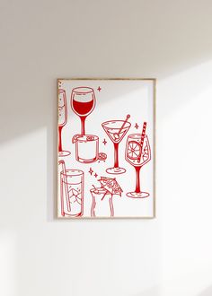 a red and white drawing on the wall next to a wine glass with a drink in it