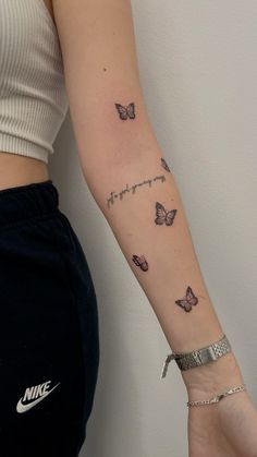 a woman's arm with butterflies on it and the word love written in cursive writing