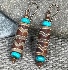 A beautiful set of Dzi Agate earrings studded with gorgeous, authentic, Kingman, Mine turquoise beads, Copper beads, and ear wires. These Wanderlust earrings offer a simple, ethnic aesthetic.  These earrings are perfect for the woman who appreciates making a statement with her jewelry. They exude a free spirit that also desires a bit of upscale style! This jewelry, accessorizes, many types of outfits and the warm tones of the Himalayan dzi agate beads is wonderful with both casual day and evening wear. The rich aqua of the genuine turquoise beads is a wonderful compliment to the rich brown tones in these earrings, and harmonizes well with their copper accents. COUPON CODES: Save 10% on purchases totaling $100 or more- enter coupon code 'SAVE10PERCENT' at checkout! Save 15% on purchases tot Ethnic Aesthetic, Beaded Jewelry Necklaces, Copper Accents, Agate Earrings, Ethnic Earrings, Brown Tones, Genuine Turquoise, Agate Beads, Turquoise Earrings