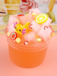 a cup filled with ice and fruit on top of a pink tablecloth next to a wall