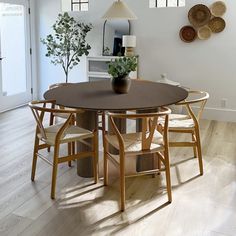 a dining room table with four chairs and a potted plant on top of it