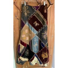 a multicolored patchwork skirt hanging on a wooden door