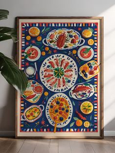 an art work with various fruits and vegetables on it in a wooden frame next to a potted plant