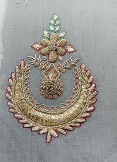 an embroidered piece with flowers and leaves on it