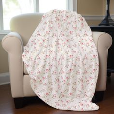 a white chair with a pink flowered blanket on it