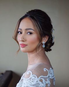 a woman wearing a wedding dress and earrings