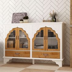 a white and wood cabinet with glass doors