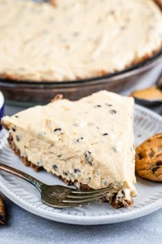 a piece of pie on a plate with a fork next to it and some cookies