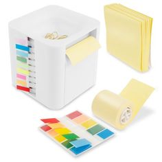 a set of sticky notes and colored paper next to a box with stickers on it