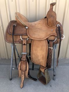 a brown saddle sitting on top of a metal stand