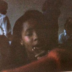 a woman is talking on her cell phone in the dark while others watch from behind