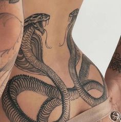 two women with tattoos on their stomachs and one has a snake tattooed on the side