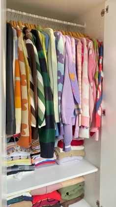 a closet filled with lots of colorful sweaters