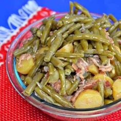 a glass bowl filled with green beans and potatoes