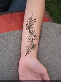 a woman's arm with a henna tattoo on her left wrist and the words,