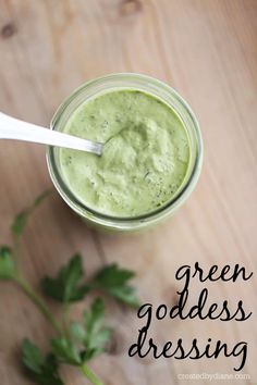 green goddess dressing in a mason jar on a wooden table with parsley around it