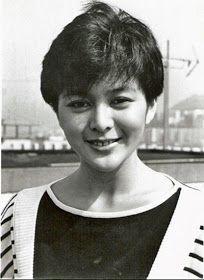 black and white photograph of a young woman with short hair smiling at the camera,