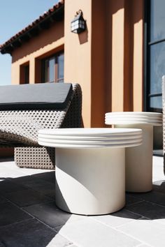 several white plates sitting on top of a table next to a chair and a building