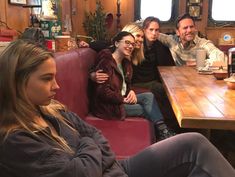 a group of people sitting around a wooden table