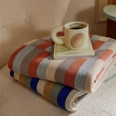 two blankets and a coffee mug on top of each other