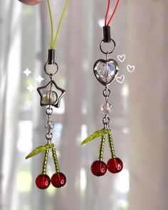 a pair of earrings with cherries hanging from them