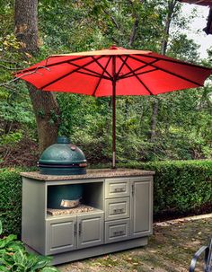 an outdoor grill and umbrella in the backyard