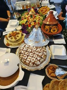 a table with many different types of desserts on it, including cakes and pies