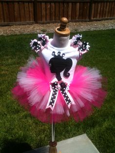 a pink and white tutu skirt on top of a mannequin in the grass